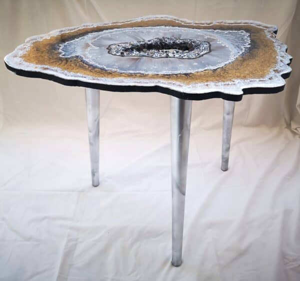 Silver bronze resin table with stones in the middle and wooden legs in silver