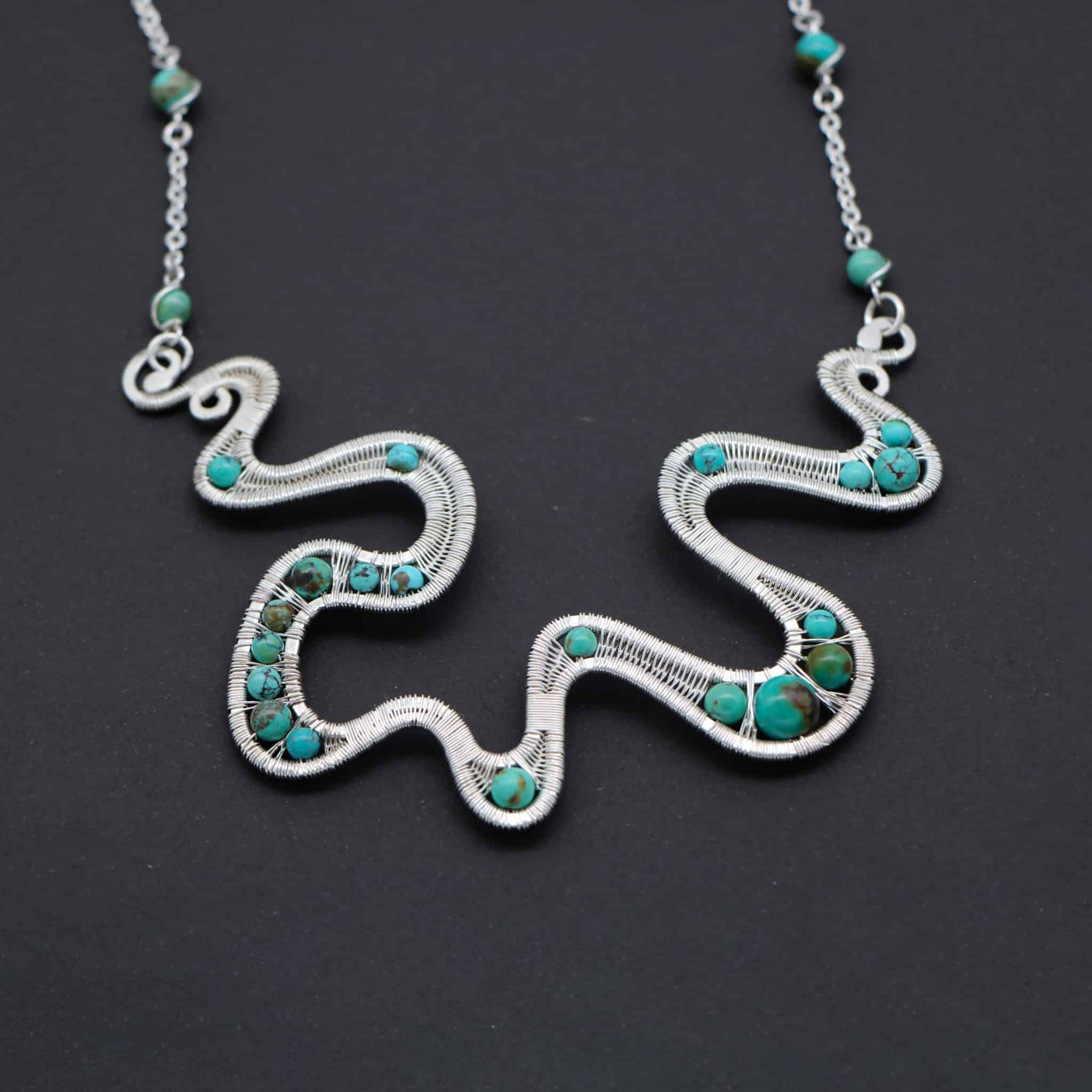 Wire wrapped silver necklace with turquoise gemstones . 1 Wire wrapped silver necklace with turquoise gemstones .