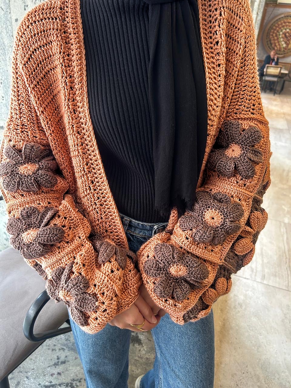 Autumn Bloom Crochet Cardigan 2 Handmade crochet cardigan featuring large 3D floral granny-square patterns in warm orange and brown tones.
