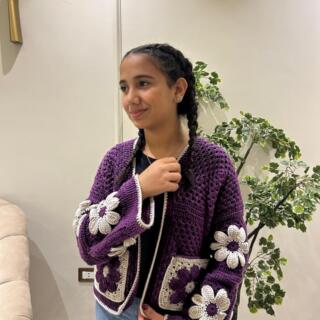 Handmade crochet cardigan in deep purple with large cream and purple 3D floral granny-square details and contrasting trim.
