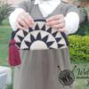 A black and off-white handmade tapestry crochet half-moon clutch