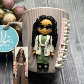 Handmade polymer clay mug featuring a custom doctor doll inspired by the owner’s photo, wearing her favorite colors with her name written on the mug.