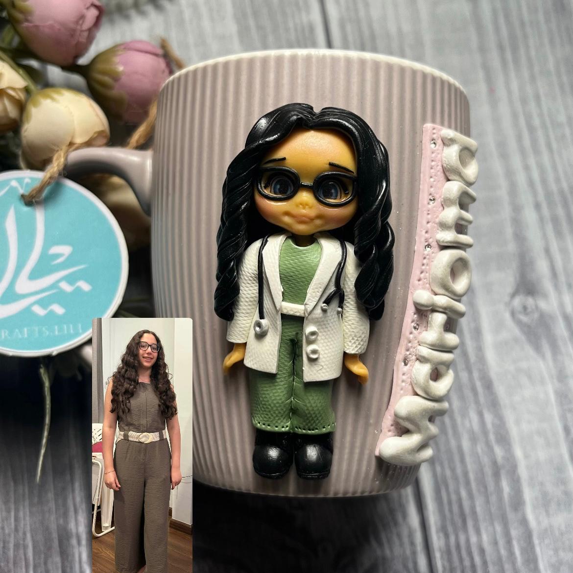 Personalized Doctor Mug – Handmade Polymer Clay 1 Handmade polymer clay mug featuring a custom doctor doll inspired by the owner’s photo, wearing her favorite colors with her name written on the mug.