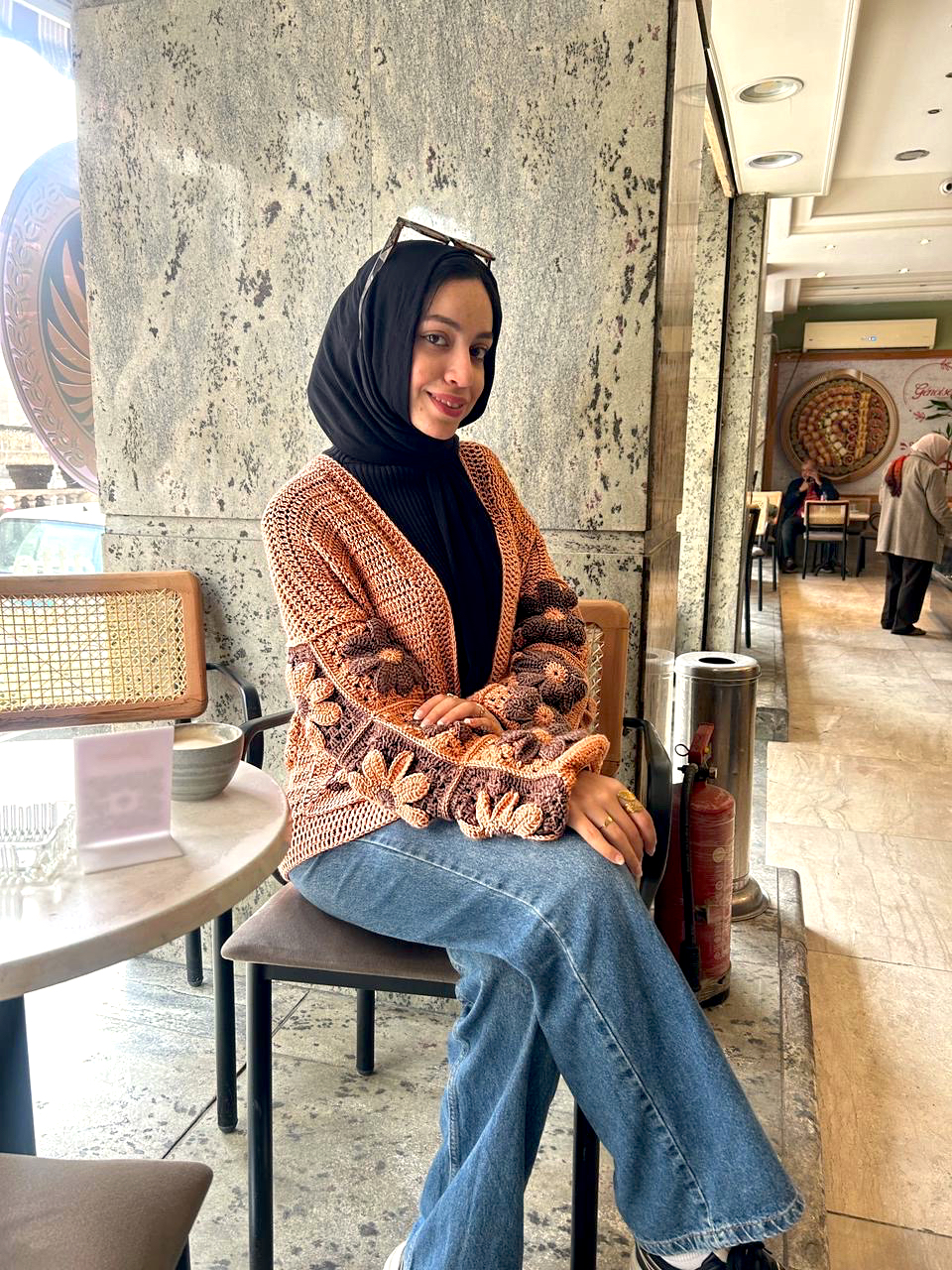 Autumn Bloom Crochet Cardigan 4 Handmade crochet cardigan featuring large 3D floral granny-square patterns in warm orange and brown tones.