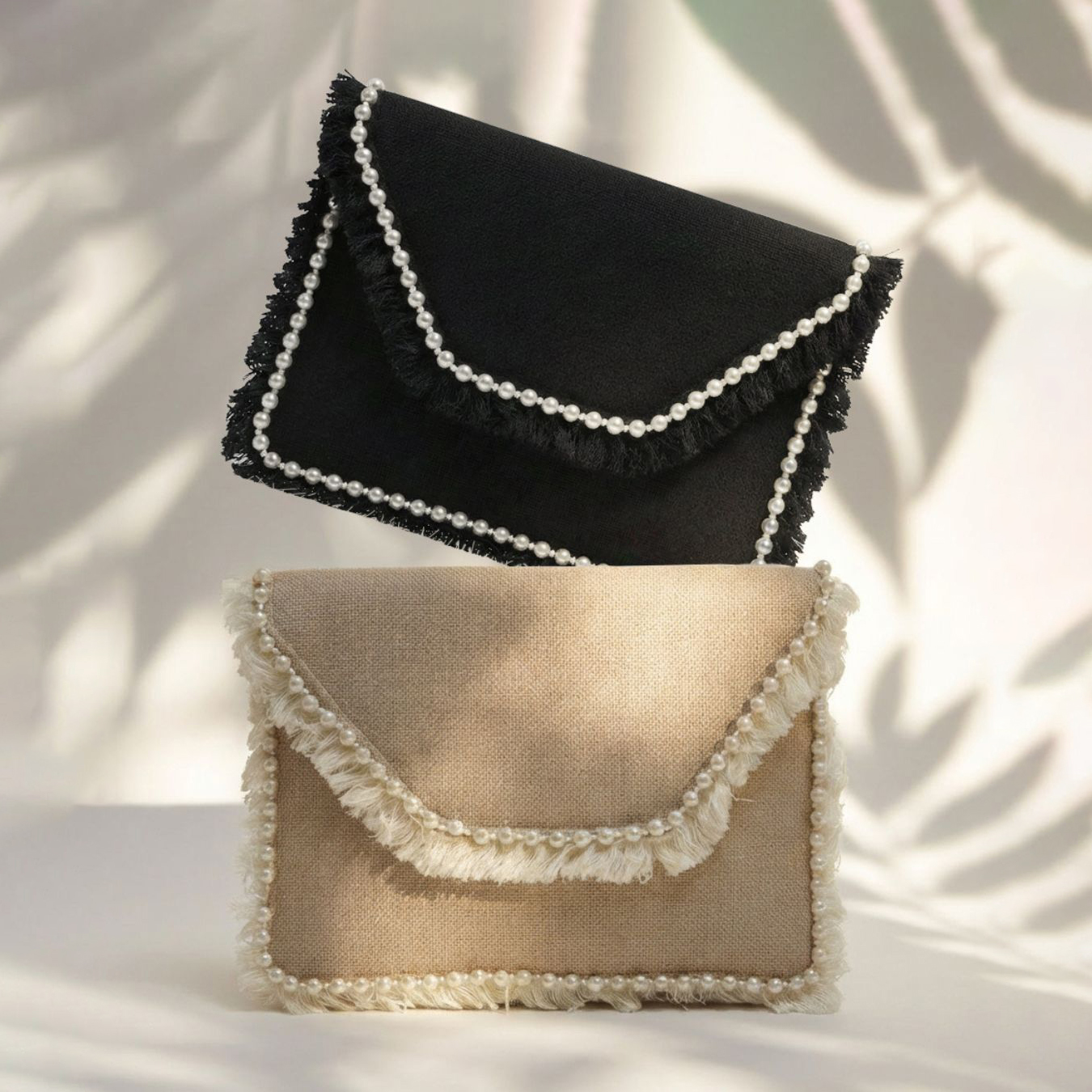 Clutch لؤلؤ 1 2 clutch bags one in black color and the the other in beige color with with pearls border