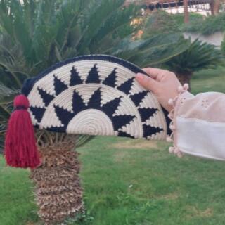 A black and off-white handmade tapestry crochet half-moon clutch