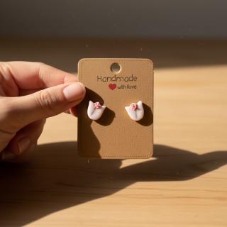 Handmade white tulip clay earrings with glitter detail displayed on a card