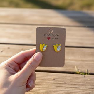 Handmade yellow tulip clay earrings with glitter detail displayed on a card