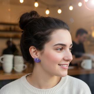 Handmade polymer clay daisy flower earrings with a fan-shaped design and glitter details in soft nude color, displayed on a card by the beach at sunset
