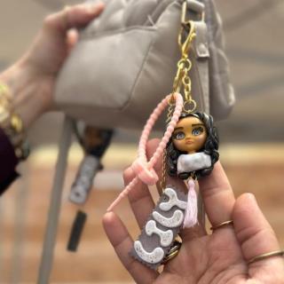 Custom handmade bag charm of a girl with personalized name and stainless steel keychain.