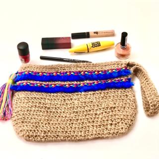 Handmade jute crochet clutch with colorful blue woven detailing and a multicolor tassel.
