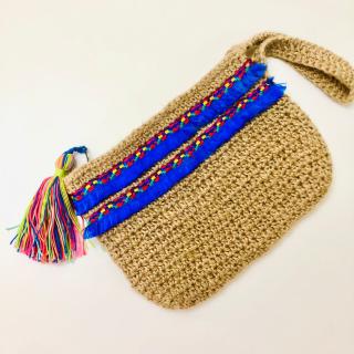 Handmade jute crochet clutch with colorful blue woven detailing and a multicolor tassel.