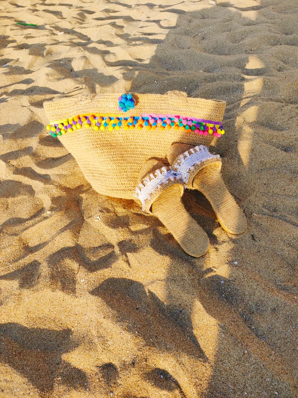 PomPom Jute Tote 3 Handmade jute crochet tote bag with colorful pom-pom trim and sturdy shoulder straps.