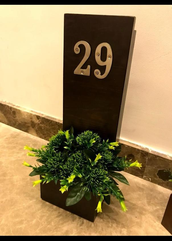 plain door sign with artificial flowers 5 cropped WhatsApp Image 2026 05 22 at 13.42.25 1