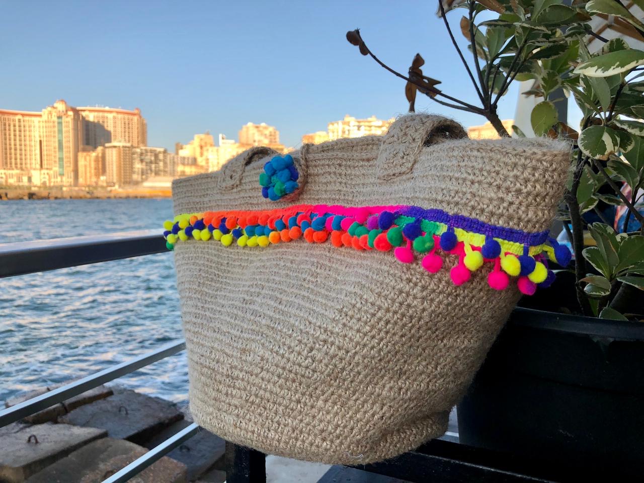 PomPom Jute Tote 2 Handmade jute crochet tote bag with colorful pom-pom trim and sturdy shoulder straps.